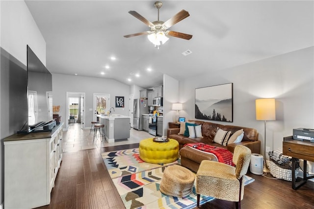 living room featuring visible vents, a ceiling fan, lofted ceiling, and wood finished floors