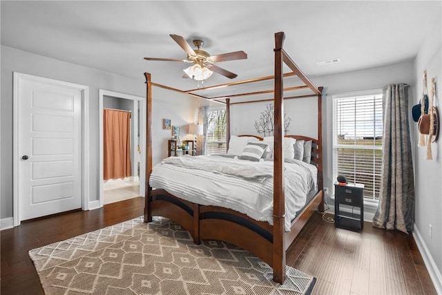 bedroom featuring baseboards, wood finished floors, and visible vents