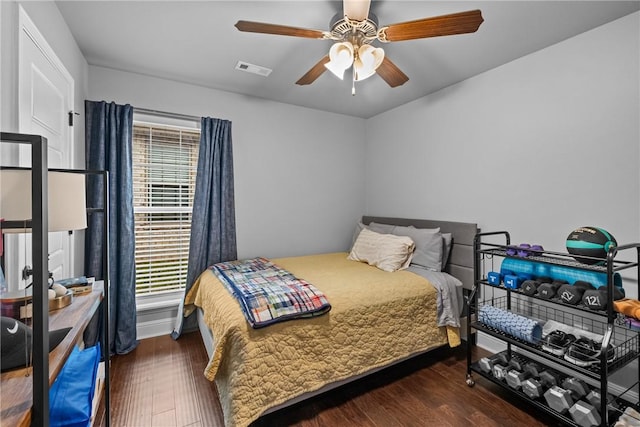 bedroom featuring a ceiling fan, wood finished floors, and visible vents