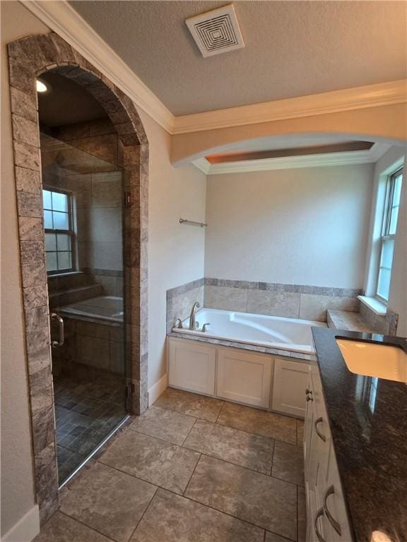 full bathroom featuring vanity, a shower stall, visible vents, ornamental molding, and a garden tub