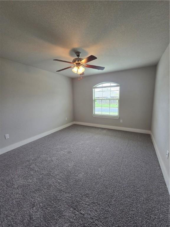spare room with carpet floors, a textured ceiling, ceiling fan, and baseboards