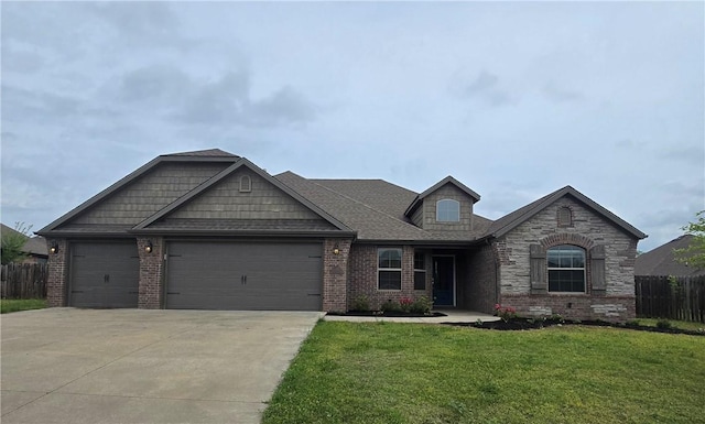 view of front facade with an attached garage, fence, a front yard, and brick siding