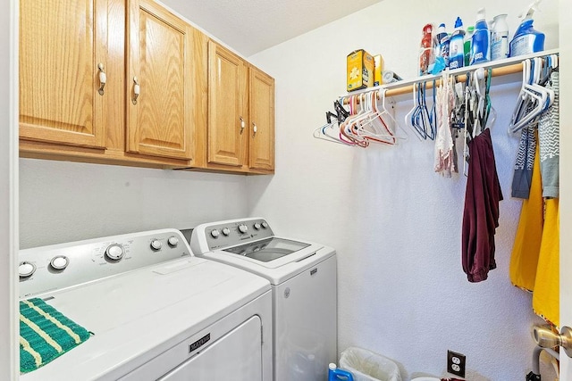 washroom featuring cabinet space and washing machine and clothes dryer