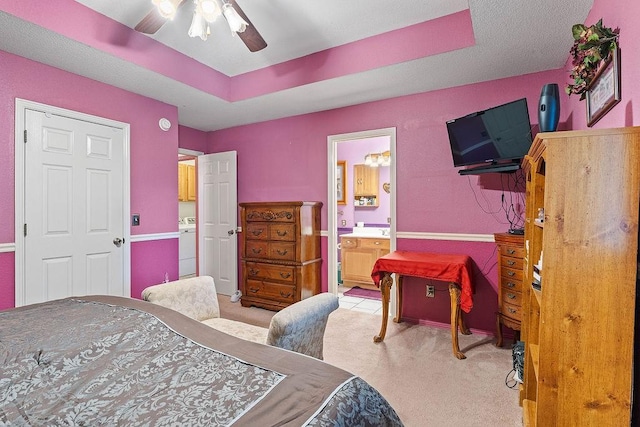 bedroom with ceiling fan, washer / dryer, carpet, and ensuite bath