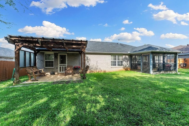 back of house featuring a sunroom, brick siding, fence, a yard, and a patio