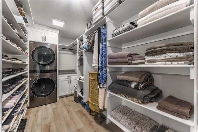 interior space featuring stacked washing maching and dryer and light wood finished floors