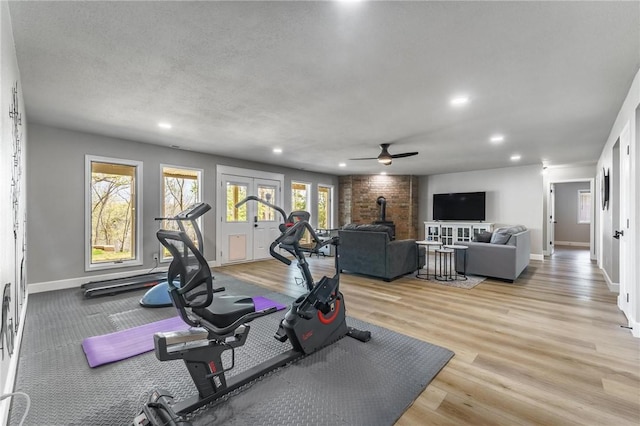 workout area with recessed lighting, a wood stove, baseboards, and ceiling fan