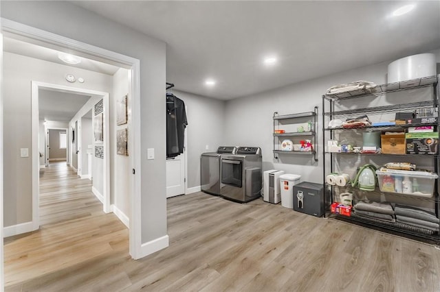 clothes washing area with laundry area, washing machine and dryer, baseboards, light wood-style floors, and recessed lighting