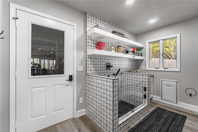 laundry area featuring a bar, recessed lighting, baseboards, and wood finished floors