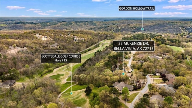 birds eye view of property featuring golf course view and a forest view