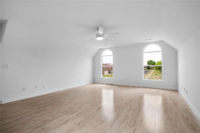 interior space featuring ceiling fan, wood finished floors, vaulted ceiling, and a healthy amount of sunlight
