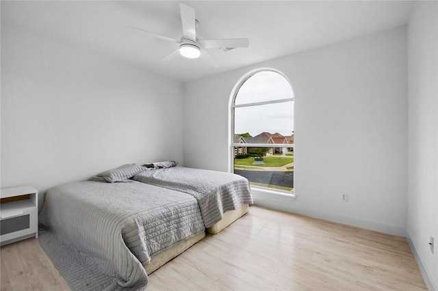 bedroom featuring a ceiling fan, wood finished floors, and visible vents