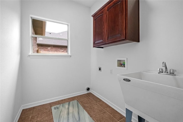 laundry room with washer hookup, electric dryer hookup, cabinet space, a sink, and baseboards