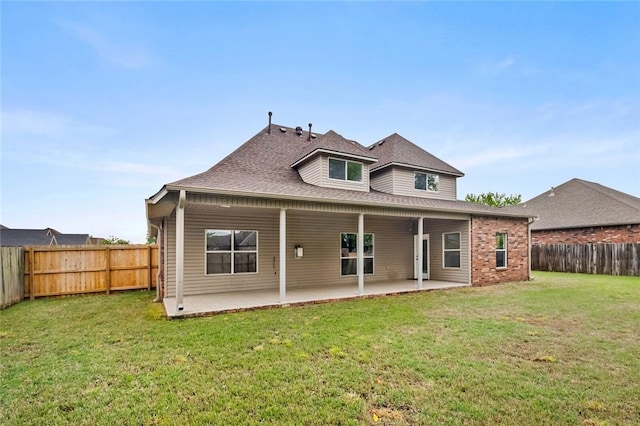 back of property with a yard, a patio, a shingled roof, and a fenced backyard