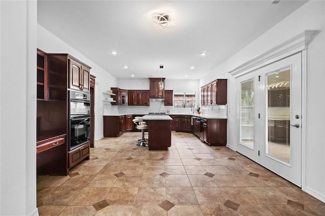 kitchen with open shelves, a breakfast bar, light countertops, dobule oven black, and a center island