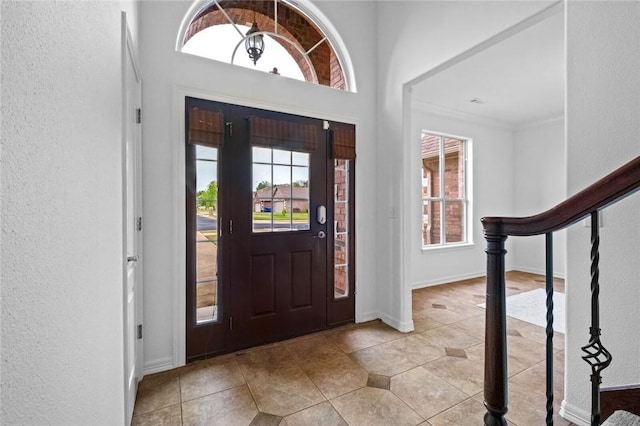 entryway featuring light tile patterned flooring, a textured wall, and a wealth of natural light