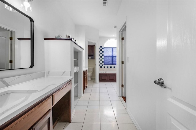 bathroom with a bath, visible vents, tile patterned flooring, vanity, and toilet