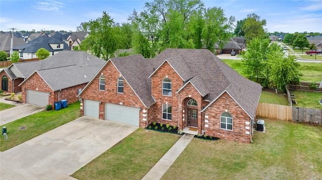 traditional home with fence, driveway, a front lawn, and a residential view