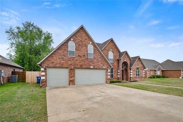 traditional-style house featuring an attached garage, fence, driveway, and a front yard