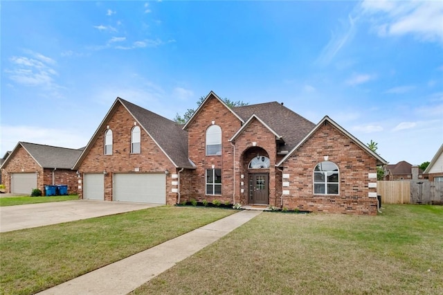 traditional-style house featuring a garage, a front lawn, fence, brick siding, and concrete driveway