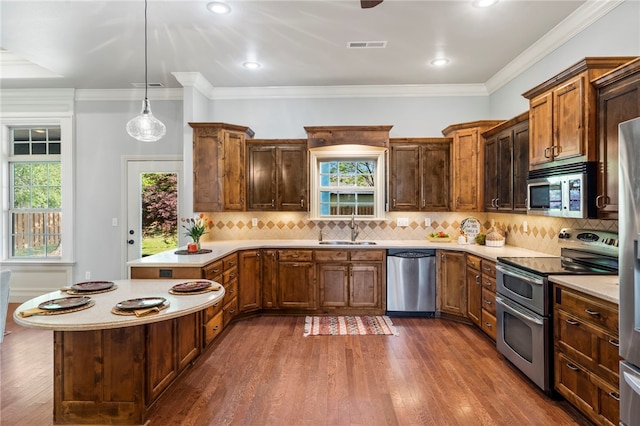 kitchen featuring light countertops, a sink, a peninsula, and stainless steel appliances
