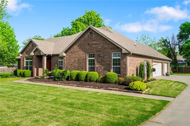 view of front of property featuring brick siding, driveway, fence, and a front lawn