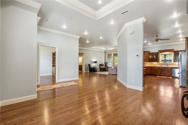 unfurnished living room with a ceiling fan, ornamental molding, and a healthy amount of sunlight
