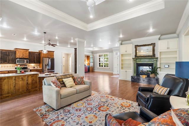 living room with a ceiling fan, dark wood-style floors, and ornamental molding