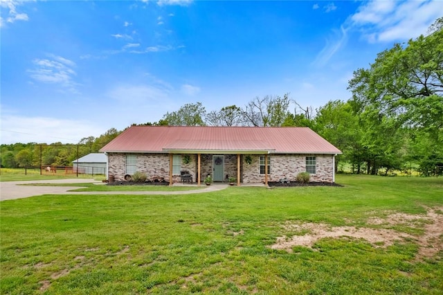 view of front of house with driveway, a front yard, and metal roof