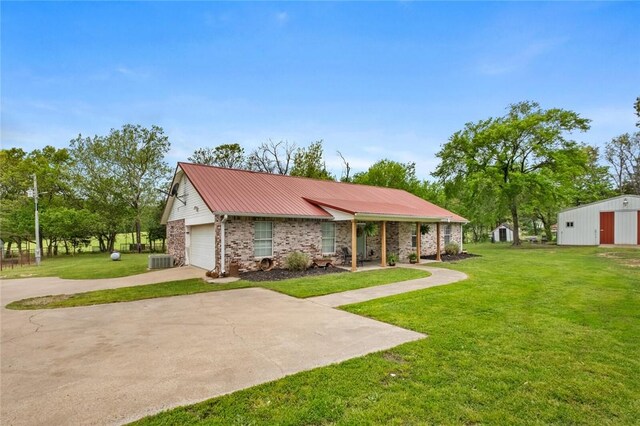 single story home with a garage, metal roof, driveway, and a front lawn