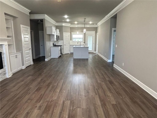 unfurnished living room with crown molding, dark wood-style flooring, built in features, a fireplace, and baseboards