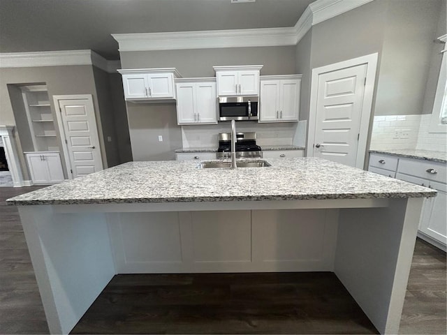 kitchen featuring crown molding, stainless steel appliances, an island with sink, and a sink