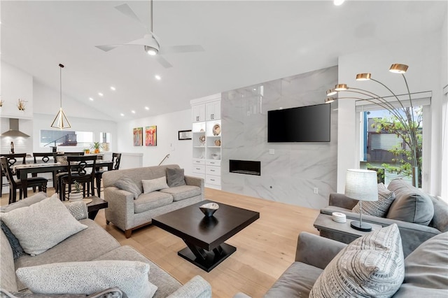 living room with ceiling fan, tile walls, high vaulted ceiling, light wood finished floors, and recessed lighting