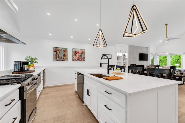 kitchen with a sink, a ceiling fan, white cabinetry, stainless steel dishwasher, and range with gas cooktop