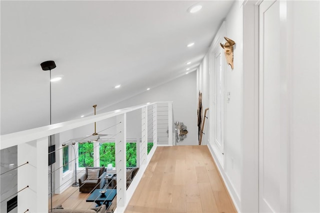 hallway with light wood-style floors, recessed lighting, and lofted ceiling