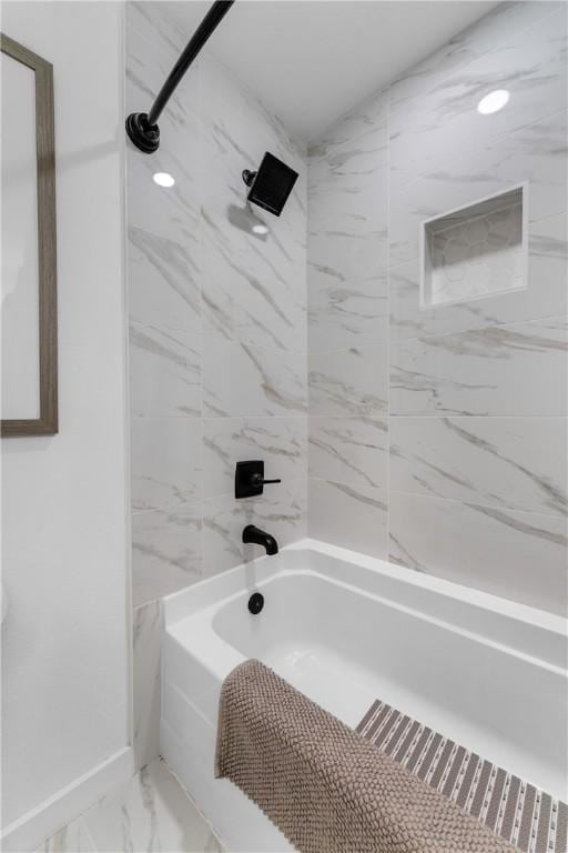 full bathroom with washtub / shower combination, baseboards, and marble finish floor