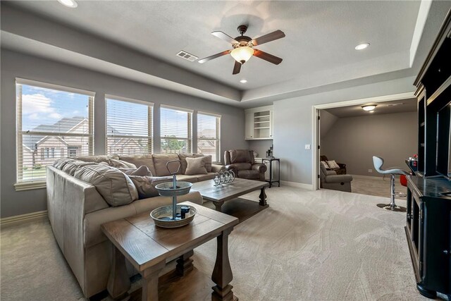 living room with light colored carpet, baseboards, ceiling fan, and a healthy amount of sunlight