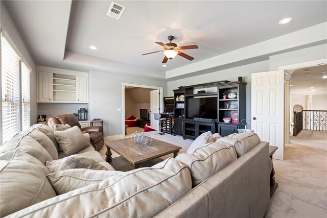 living room featuring visible vents, light carpet, recessed lighting, a raised ceiling, and a ceiling fan