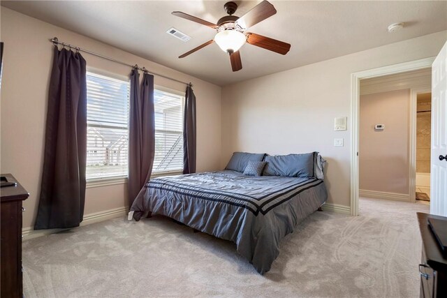 bedroom with baseboards, light colored carpet, and visible vents
