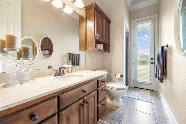 bathroom featuring crown molding, tile patterned floors, baseboards, vanity, and toilet