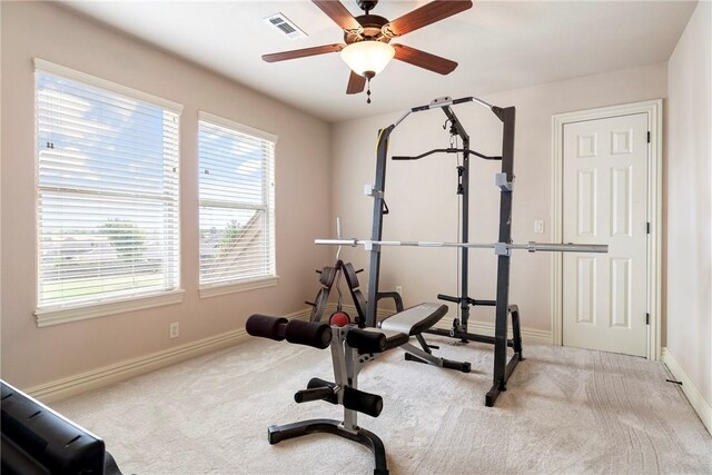 workout room featuring carpet floors, a ceiling fan, baseboards, a healthy amount of sunlight, and visible vents