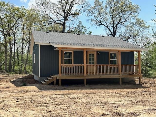 view of front facade with covered porch and a shingled roof