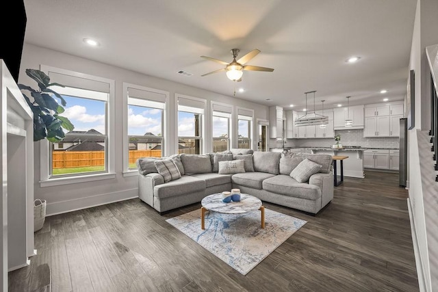 living room with baseboards, ceiling fan, recessed lighting, and dark wood-type flooring