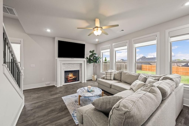 living area with visible vents, baseboards, ceiling fan, and a healthy amount of sunlight