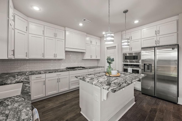 kitchen featuring white cabinets, backsplash, stainless steel appliances, and dark wood-style floors