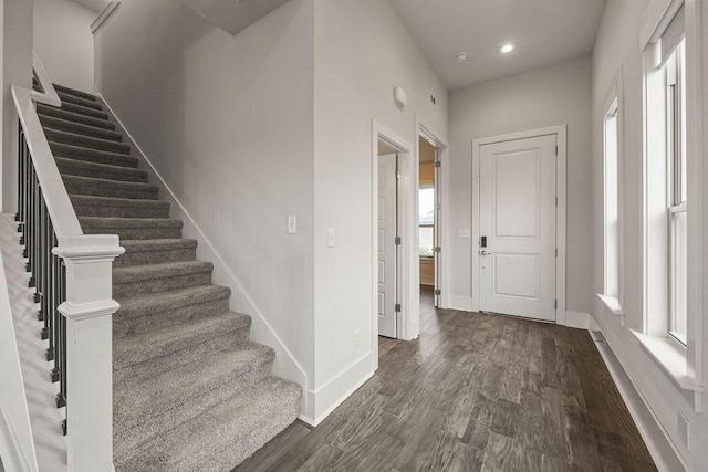 entryway with baseboards, recessed lighting, stairs, and dark wood-type flooring
