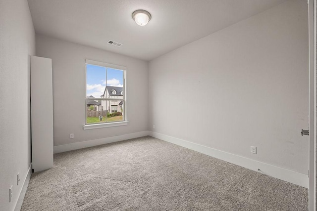 carpeted empty room featuring visible vents and baseboards