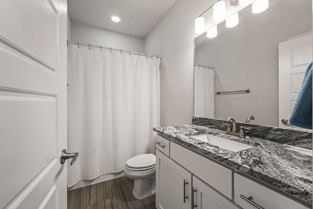 bathroom featuring vanity, toilet, a shower with shower curtain, recessed lighting, and wood finished floors