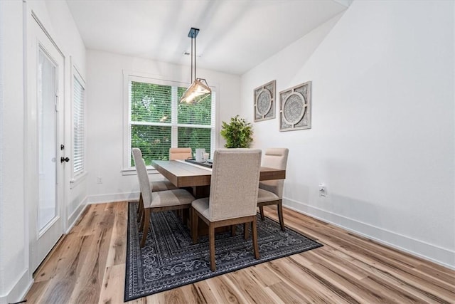 dining space featuring light wood-style floors and baseboards