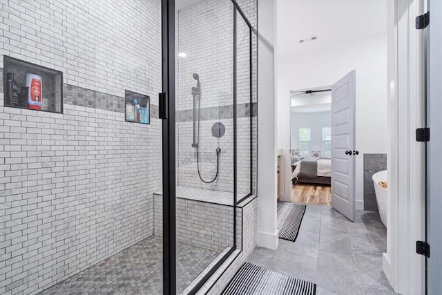 ensuite bathroom with connected bathroom, baseboards, a shower stall, and a soaking tub
